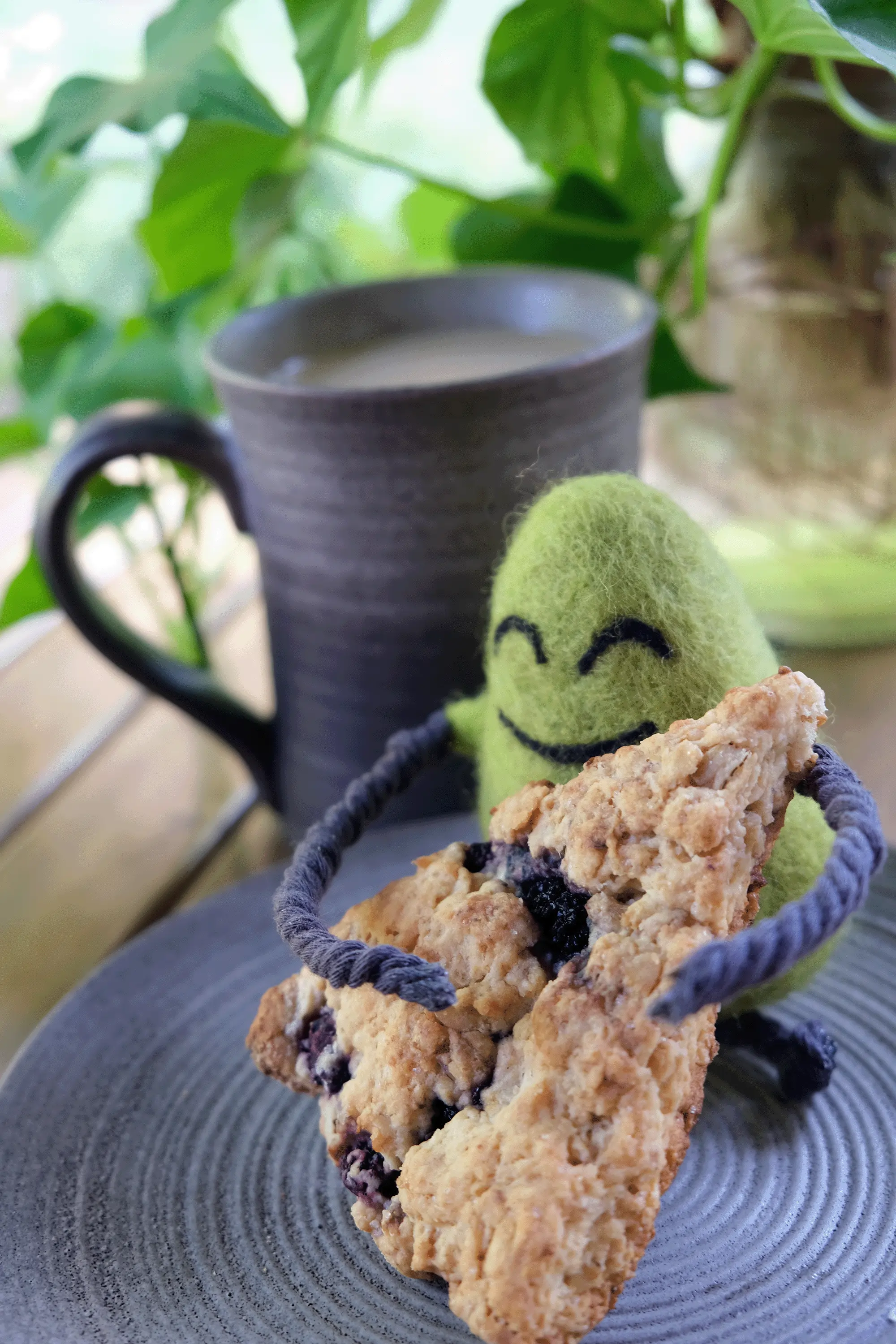 A felted Cloudia hugging a scone